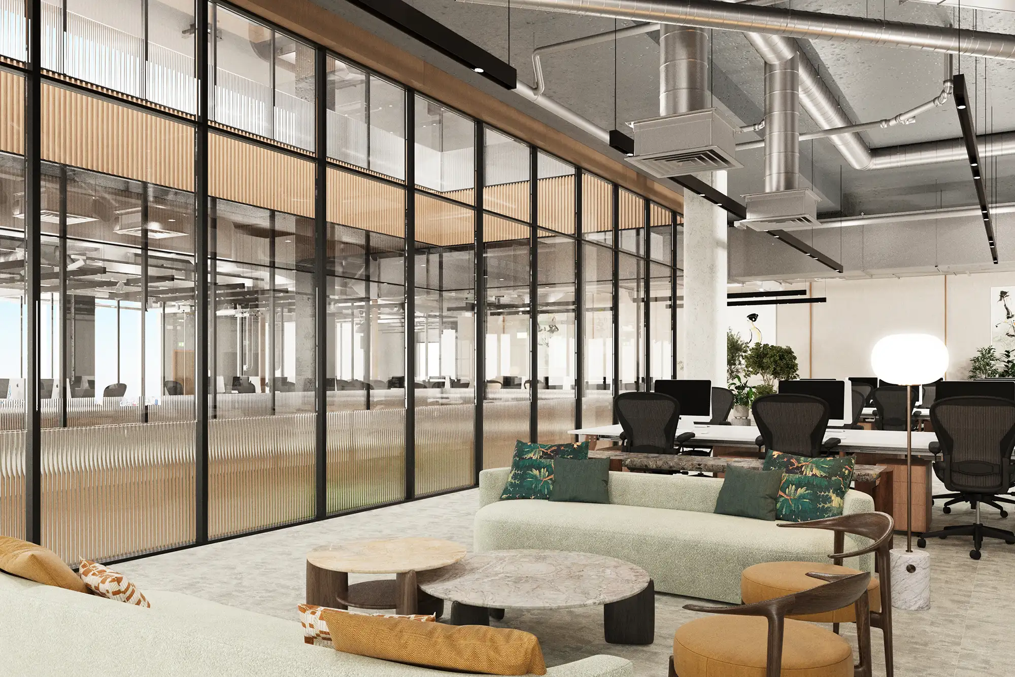 Modern office interior with glass partitions, plush seating area, and visible ductwork on the ceiling.